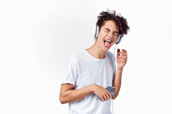Fröhlicher Kerl mit Kopfhörer hört Musik Emotionen Licht Hintergrund — Stockfoto