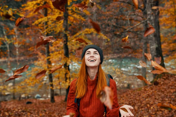 Mulher alegre viaja na floresta de outono na natureza perto do rio e árvores altas no fundo — Fotografia de Stock