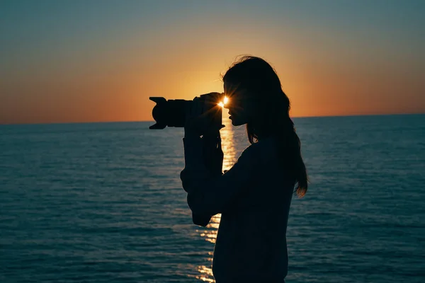 Touristin hält professionelle Kamera auf Natur Landschaft Sonnenuntergang — Stockfoto