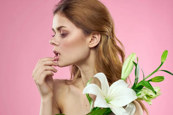 Hermosa mujer flores ramo cosméticos hombros desnudos fondo rosa — Foto de Stock