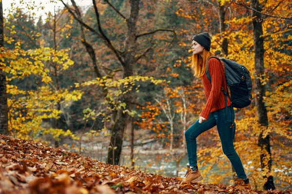 Žena v podzimním lese v blízkosti řeky krajina žluté listy turistika — Stock fotografie