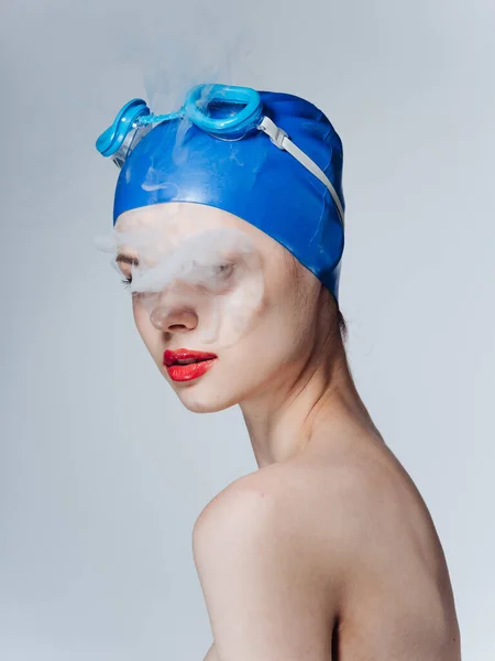 Fumador nadador en una gorra azul y humo de la boca — Foto de Stock