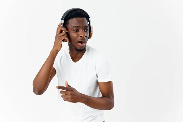 Hombre de apariencia africana escucha música con auriculares emociones — Foto de Stock