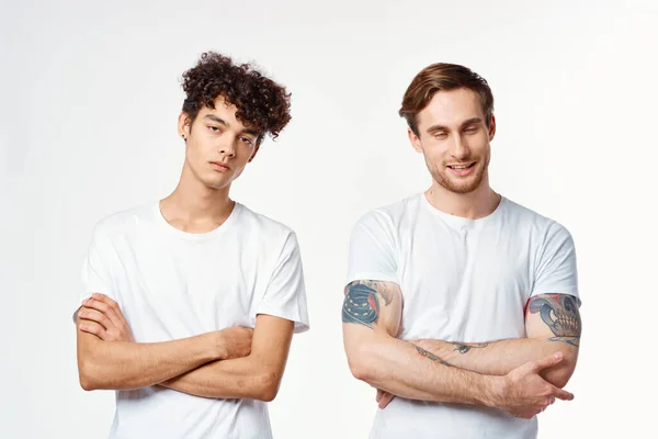 Divertente due uomini in bianco t-shirt sono in piedi fianco a fianco isolato sfondo — Foto Stock