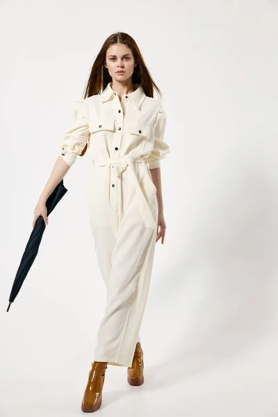 女性で白いジャンプスーツで傘で手保護から雨のファッションブランド — ストック写真
