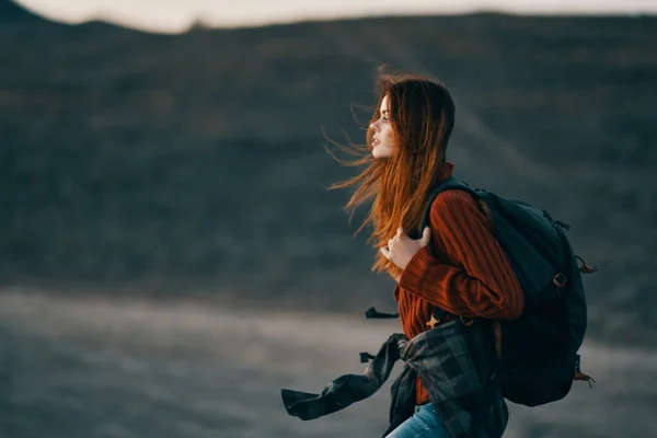Una donna in una teoria famiglia viaggia nella natura in montagna con uno zaino sulle spalle — Foto Stock