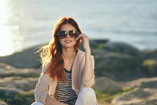 Szczęśliwy podróżnik o zachodzie słońca w górach w pobliżu morza w letnich okularach koszulka w paski sweter — Zdjęcie stockowe