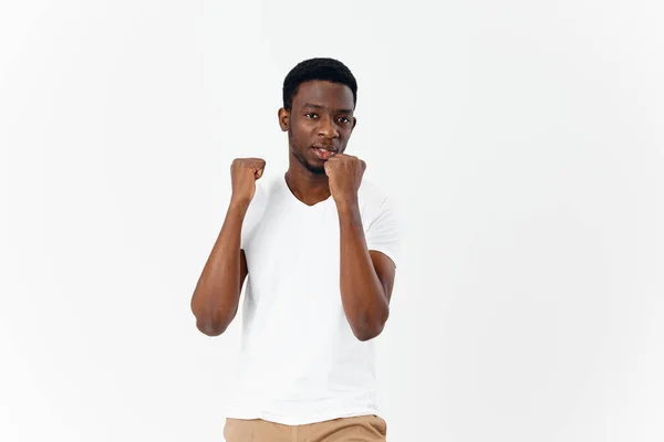 Afro-americano en camiseta blanca gestos con sus manos emociones estudio — Foto de Stock