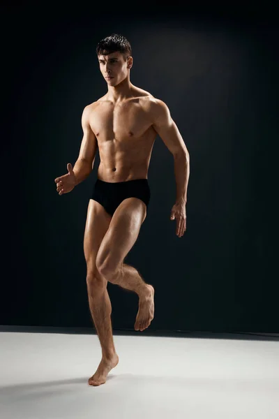 근육질의 몸을 검은 팬티를 입고 있는 활달 한 남자 — 스톡 사진