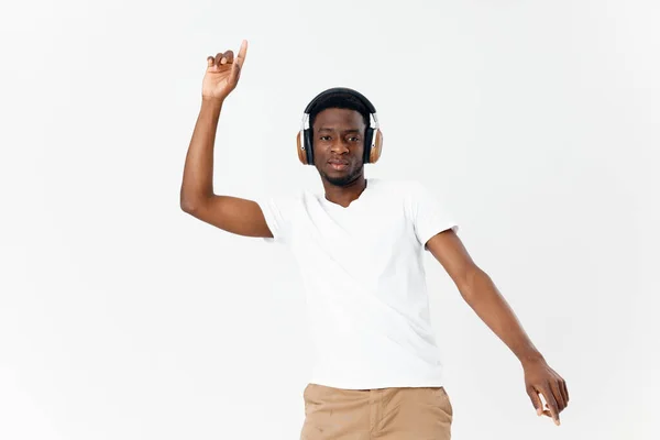 Homme d'apparence africaine dans les écouteurs gesticulant avec les mains — Photo