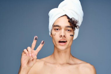 Başında havlu olan çıplak omuzlu bir adam.