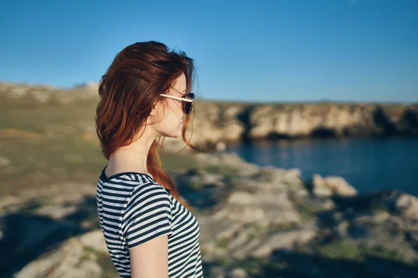 Modelo mujer de viaje en camiseta y gafas cerca del río en las montañas — Foto de Stock