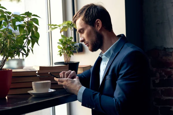 Uomo d'affari in giacca e cravatta seduto a un tavolo in un bar tempo libero colazione professionale — Foto Stock