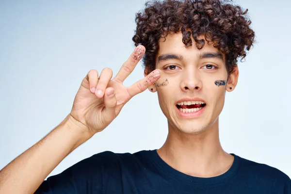 Stilig man med lockigt hår svart kosmetika hand gest — Stockfoto