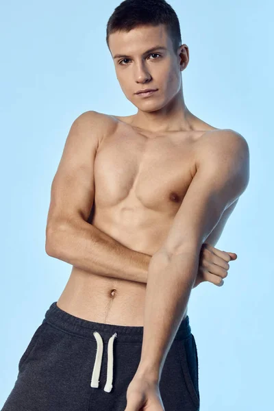 Topless ragazzo atletico fisico allenamento sfondo blu — Foto Stock