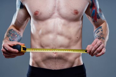 Kolunda santimetre bant, vücut geliştirme modeli dövmesi olan sevimli bir sporcu.