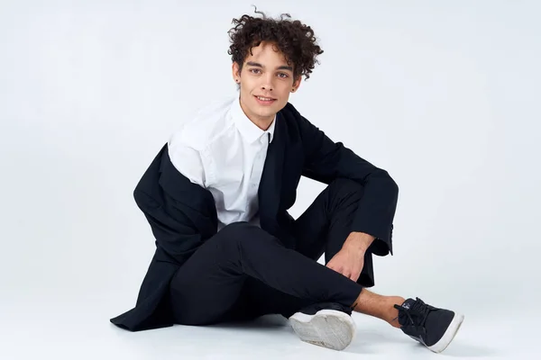 Hombre guapo en traje sentado en el piso de la moda confianza luz fondo —  Fotos de Stock