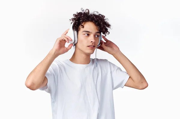 Kudrnatý chlap ve sluchátkách poslouchá hudbu emoce zábava — Stock fotografie