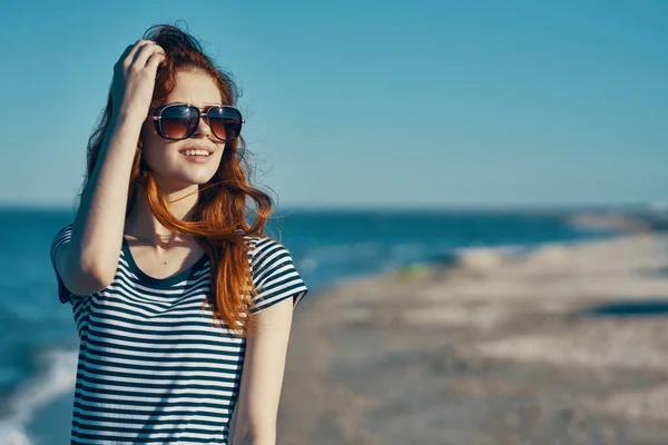Piękna kobieta z czerwonymi włosami odpoczywająca w przyrodzie na plaży w pobliżu morza latem — Zdjęcie stockowe