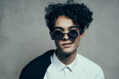 Gözlüklü mutlu adam. Kıvırcık saçlı. Gülümse.