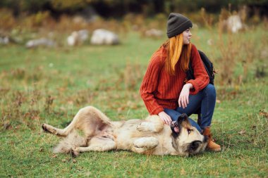 Dağlarda köpeğin yanındaki kadın yürüyüşçü. 