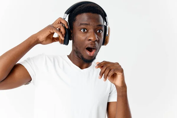 stock image African American with a surprised expression in headphones listening to music