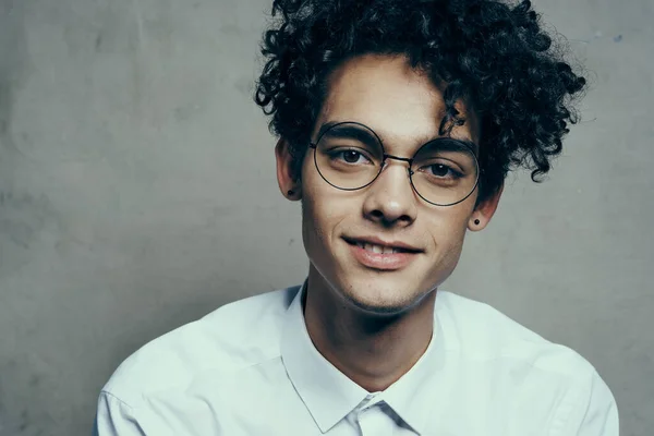 Curly-haired man in glasses and in a white shirt on a fabric background smile model close-up portrait — Stock Photo, Image