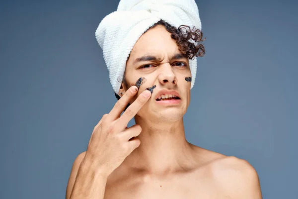 Pohledný chlap s ručníkem na hlavě nahý ramena kosmetika čistá kůže — Stock fotografie