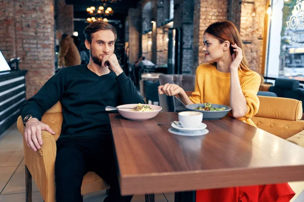 Alegre jovem casal sentado em um restaurante descansar comendo — Fotografia de Stock