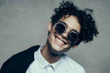 Gözlüklü mutlu adam. Kıvırcık saçlı. Gülümse.