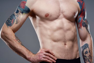 Kollarında şişmiş gövde dövmesi olan bir adam.