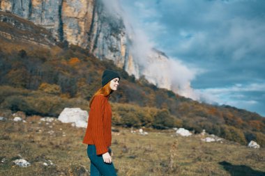Doğa kadını, dağ turizmi modelinde kazak ve şapkayla seyahat eder.