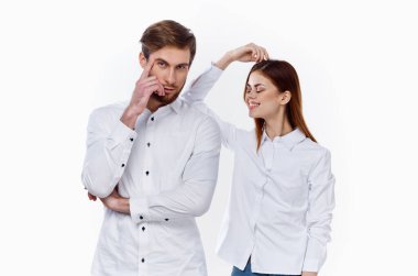 Gömlekli bir iş adamı ve arka planda çalışan bir kadın partnerlerinin elleriyle el kol hareketi yapıyor.