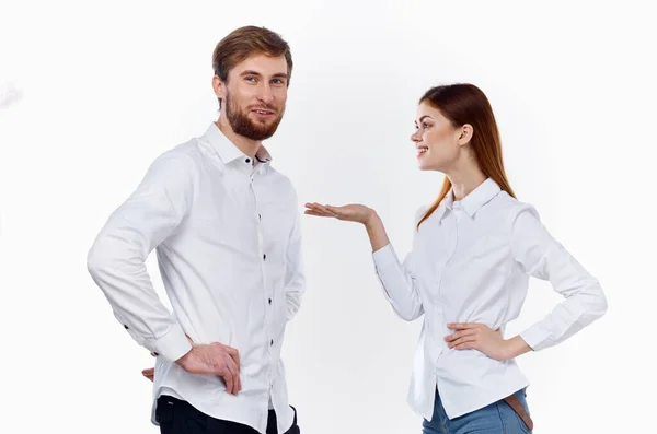 Egy férfi és egy nő azonos ingben gesztikulálnak a kezükkel egy könnyű háttér. — Stock Fotó