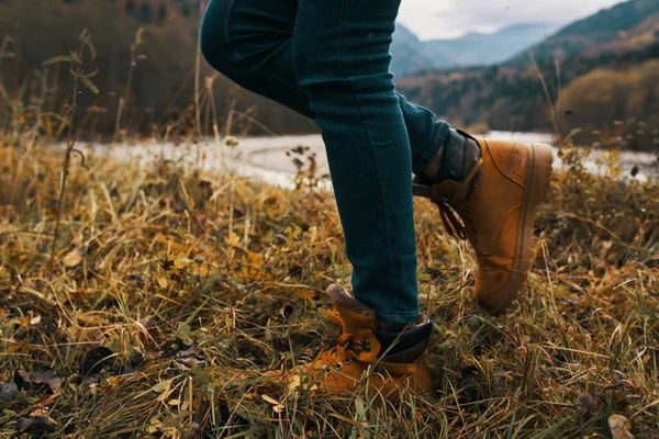 Frauenbeine in Stiefeln und Jeans über die Natur im Herbst in den Bergen — Stockfoto