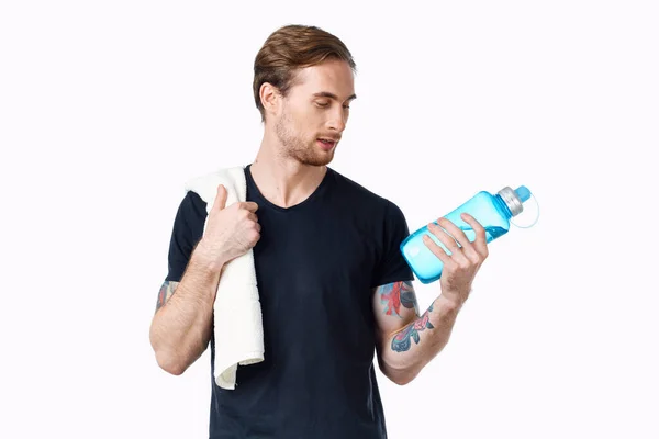 Homem desportivo em preto t-shirt treino garrafa de água — Fotografia de Stock