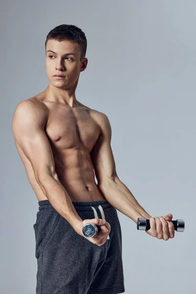 Sportos férfi súlyzókkal a kezében edzés szivattyúzott fel sajtó kivágott kilátás tornaterem életmód — Stock Fotó