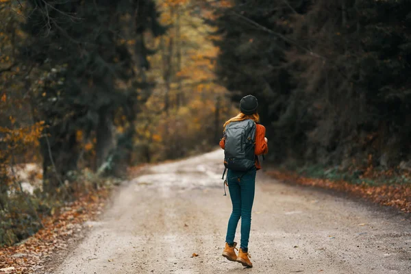 Viajero feliz con paseos en mochila en el camino en el bosque de otoño — Foto de Stock