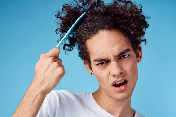 Problémy s česáním vlasů mladý chlap v tričku a česání kudrlinky model — Stock fotografie