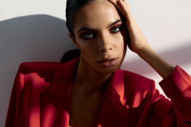 Gece makyajlı ve kırmızı ceketli seksi bir esmer portresi.