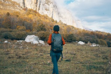 Sonbaharda kadın ormanda doğada mavi gökyüzü dağlarında manzara