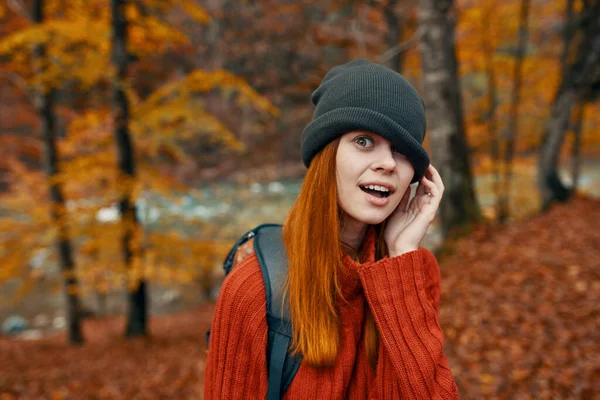 Kobieta w kapeluszu i swetrze z plecakiem na plecach zabawa jesień krajobraz rzeka — Zdjęcie stockowe