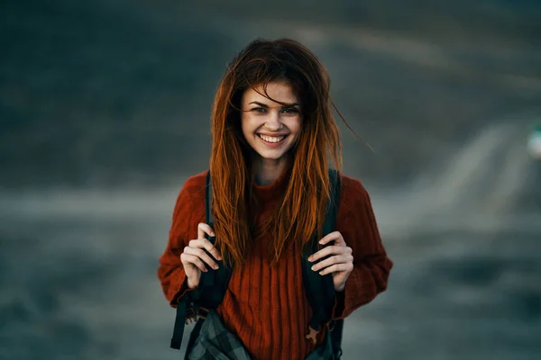 Szczęśliwy podróżnik w czerwonym swetrze śmieje się na zewnątrz w pobliżu gór na zewnątrz — Zdjęcie stockowe