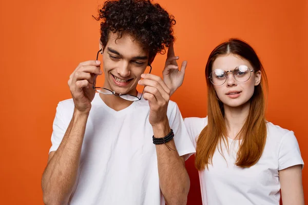 Vrolijk jong paar dragen bril emotie oranje achtergrond mode — Stockfoto