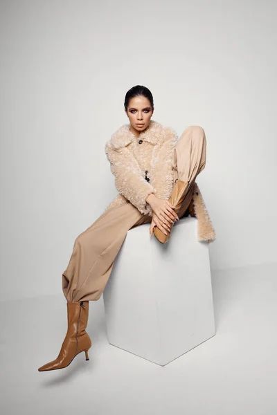 Mulher na moda no casaco sentado em botas marrons moda estilo outono — Fotografia de Stock