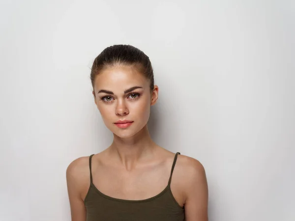 Young woman in a t-shirt on a light background hairstyle makeup — 스톡 사진