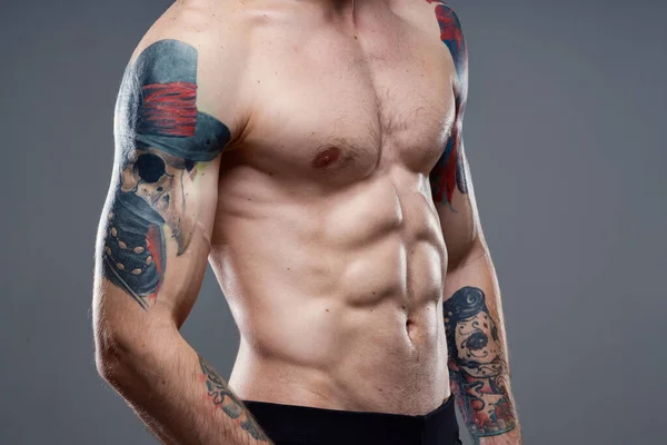 Homme sportif avec abdos pompé vue recadrée du tatouage sur les bras gros plan — Photo