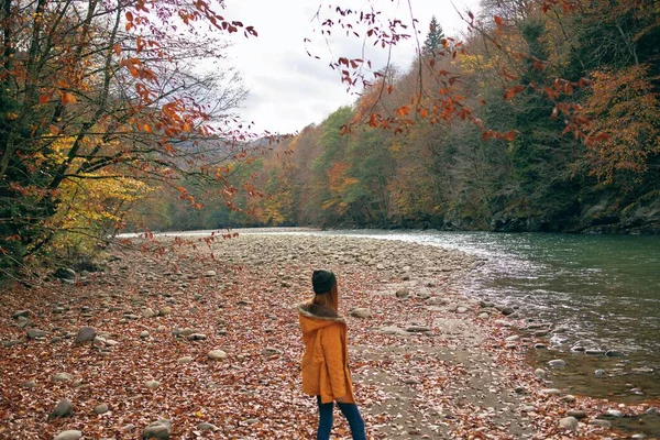 Vrouw in een geel jasje bij de rivier bergen natuur wandeling — Stockfoto