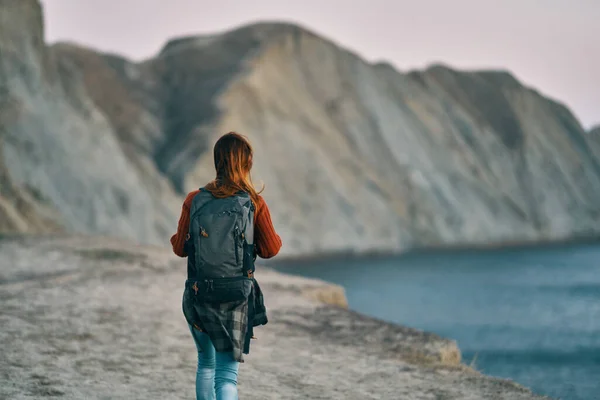 Жінка в горах біля моря і скелі на фоні природи свіже повітря — стокове фото