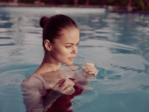 Vrouw in een badpak zwemmen in het zwembad natuur rust close-up — Stockfoto